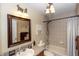 Bathroom with vanity, framed mirror, tub with shower and decorative fixtures at 825 White Birch Ct, Orange City, FL 32763