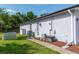 Side of house featuring a well-maintained lawn, convenient access door, and exterior utility connections at 825 White Birch Ct, Orange City, FL 32763