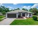 Charming single-story home featuring a well-manicured lawn, gray roof, and attached two-car garage at 825 White Birch Ct, Orange City, FL 32763