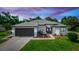 Charming single-story home featuring a well-manicured lawn, gray roof, and attached two-car garage at 825 White Birch Ct, Orange City, FL 32763