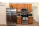Well-equipped kitchen with stainless steel appliances and wooden cabinetry at 825 White Birch Ct, Orange City, FL 32763