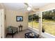 Bright sunroom with comfortable seating, ceiling fan and large windows offering serene backyard views at 825 White Birch Ct, Orange City, FL 32763