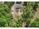 Aerial shot of home surrounded by lush trees, long driveway, and fire pit at 8660 Sw 137Th Ct, Dunnellon, FL 34432
