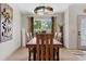 Dining area with a long wood table, decorative art, and curtains providing a warm, inviting atmosphere at 8660 Sw 137Th Ct, Dunnellon, FL 34432
