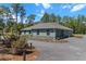 Single-story home with a long driveway, a two-car garage, and beautiful landscaping at 8660 Sw 137Th Ct, Dunnellon, FL 34432