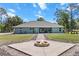 Outdoor fire pit area, offering a relaxing space with a view of the modern blue home at 8660 Sw 137Th Ct, Dunnellon, FL 34432