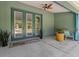 Inviting covered patio with ceiling fan, green French doors, and outdoor seating area at 8660 Sw 137Th Ct, Dunnellon, FL 34432