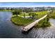Picturesque aerial view of the community lake with a pier and sitting area, complemented by walking paths and green spaces at 8679 Laureate Blvd, Orlando, FL 32827