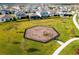 A picturesque aerial view of a community playground surrounded by lush green lawns and neighborhood homes at 8679 Laureate Blvd, Orlando, FL 32827