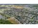 Aerial view showcases the community with a scenic lake and well-maintained streets at 8679 Laureate Blvd, Orlando, FL 32827