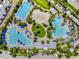 Overhead view of community pool area with multiple pools, volleyball court, and lush green spaces at 8679 Laureate Blvd, Orlando, FL 32827