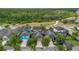Aerial view of a neighborhood with tree-lined streets, well-maintained homes, and a serene wooded backdrop at 8679 Laureate Blvd, Orlando, FL 32827