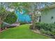 A manicured backyard features lush lawn, professional landscaping, privacy fence, and a relaxing hammock at 8679 Laureate Blvd, Orlando, FL 32827