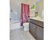 Bathroom featuring a shower over the tub, a toilet, and vanity with flowers at 8679 Laureate Blvd, Orlando, FL 32827