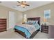 Cozy bedroom with a plush bed, dark wood furniture, and soft lighting, creating a relaxing retreat for rest and rejuvenation at 8679 Laureate Blvd, Orlando, FL 32827