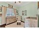 A cozy Bedroom with a crib, changing table, chair, and soft natural light at 8679 Laureate Blvd, Orlando, FL 32827