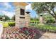 Welcome to Laureate Park, where a beautifully landscaped entrance with vibrant flowers and stone pillars greet residents and guests at 8679 Laureate Blvd, Orlando, FL 32827