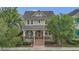 Charming two-story home featuring a welcoming front porch, well-maintained lawn, and mature trees, offering a delightful curb appeal at 8679 Laureate Blvd, Orlando, FL 32827