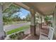 Inviting front porch with brick columns, cozy seating, and a view of the neighborhood at 8679 Laureate Blvd, Orlando, FL 32827