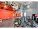Bright gym featuring spin bikes, an orange accent wall, and industrial lighting, for a modern and energetic workout space at 8679 Laureate Blvd, Orlando, FL 32827