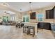 Open-concept kitchen with granite countertops, dark cabinetry, stainless steel appliances, and a breakfast bar perfect for entertaining at 8679 Laureate Blvd, Orlando, FL 32827
