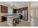 Modern kitchen featuring stainless steel appliances, granite countertops, dark cabinets, and an island with breakfast bar seating at 8679 Laureate Blvd, Orlando, FL 32827