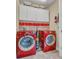 A laundry room featuring a red washer and dryer, cabinets and bins at 8679 Laureate Blvd, Orlando, FL 32827