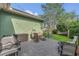 This cozy brick patio has a grill, wood storage, and a hammock for relaxing in the landscaped backyard at 8679 Laureate Blvd, Orlando, FL 32827