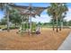 Modern community playground with colorful equipment and a soft wood-chip ground, designed for safe and fun play at 8679 Laureate Blvd, Orlando, FL 32827