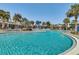 Large community pool with clear blue water, surrounded by palm trees and lounge areas at 8679 Laureate Blvd, Orlando, FL 32827