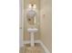 Powder room featuring a pedestal sink, oval mirror and neutral decor at 8679 Laureate Blvd, Orlando, FL 32827