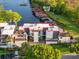 Aerial view of a multi-story home with a boat slip on the canal and a large parking area and exterior patio at 8988 Houston Pl # 303, Orlando, FL 32819