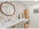 Stylish bathroom featuring a large round mirror, vanity, drawers and decorative wallpaper at 8988 Houston Pl # 303, Orlando, FL 32819