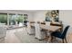 Bright dining room with large glass doors to patio, light wood floors, and area rug at 8988 Houston Pl # 303, Orlando, FL 32819