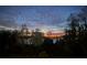 Beautiful sunset colors fill the evening sky as seen from this beautiful home, with a view of the water and the silhouetted trees at 8988 Houston Pl # 303, Orlando, FL 32819