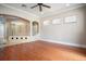 Large primary bedroom with an attached bathroom featuring glass block shower, hardwood floors and arched windows at 100 Crestwood Dr, Longwood, FL 32779