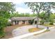Charming single-story home with brick and wood accents, attractive landscaping, and a paver driveway at 100 Crestwood Dr, Longwood, FL 32779