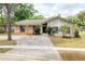 Charming home featuring brick accents, mature landscaping, and a beautiful brick paver driveway at 100 Crestwood Dr, Longwood, FL 32779