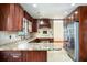 Traditional kitchen with granite countertops, custom cabinets, tile backsplash, and stainless steel refrigerator at 100 Crestwood Dr, Longwood, FL 32779
