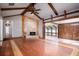 Large living room featuring fireplace with stone surround, wood floors, beamed ceiling, and access to sunroom at 100 Crestwood Dr, Longwood, FL 32779
