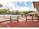 Backyard view from wood deck highlighting the uniquely shaped pool, brick patio, and cabana at 100 Crestwood Dr, Longwood, FL 32779