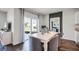 Open dining area with dark wood floors, white table, and view of the backyard at 1012 Bear Hammock Dr, Umatilla, FL 32784
