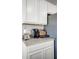 An inviting coffee station complements the kitchen's clean design with white cabinets and stone countertops at 1012 Bear Hammock Dr, Umatilla, FL 32784