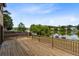 Large wooden deck overlooking a serene lake with mature trees and fenced backyard at 1103 Saddleback Ridge Rd, Apopka, FL 32703
