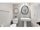 Neutral powder room with pedestal sink, oval mirror, and decorative artwork at 1103 Saddleback Ridge Rd, Apopka, FL 32703
