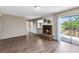 Cozy living room with wood floors, a brick fireplace, and sliding glass doors to outdoor patio at 1103 Saddleback Ridge Rd, Apopka, FL 32703