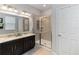 Bathroom with a dual sink vanity, granite counters, and a glass-enclosed shower at 12335 Sumter Dr, Orlando, FL 32824