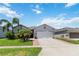 Attractive home with a well-kept lawn, mature palm trees, and a spacious driveway for easy parking at 12335 Sumter Dr, Orlando, FL 32824