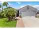 Charming single-Gathering home features lush landscaping, a brick walkway, and a two-car garage at 12335 Sumter Dr, Orlando, FL 32824