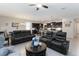 Open-concept living room featuring tile flooring, ceiling fan, and leather furniture at 12335 Sumter Dr, Orlando, FL 32824